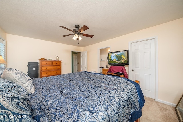 carpeted bedroom featuring baseboards, a ceiling fan, and a textured ceiling