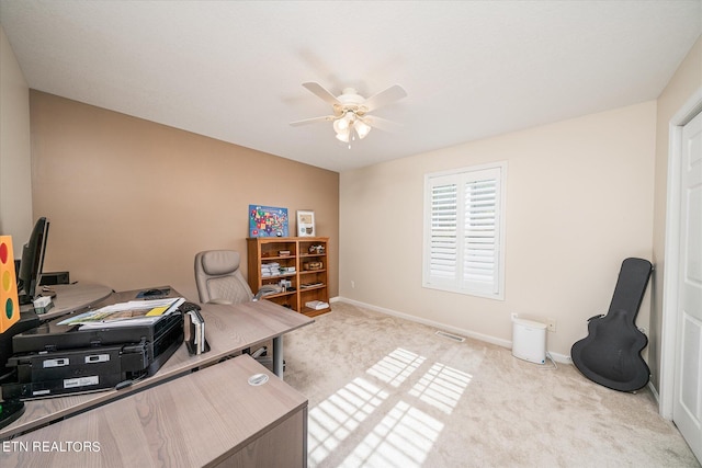 office space with a ceiling fan, light carpet, visible vents, and baseboards
