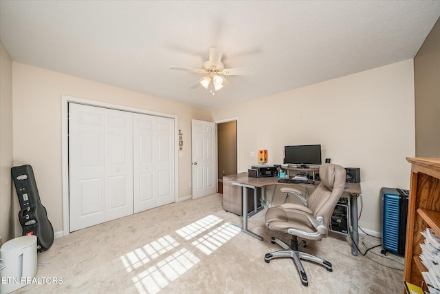 home office featuring light carpet, baseboards, and a ceiling fan