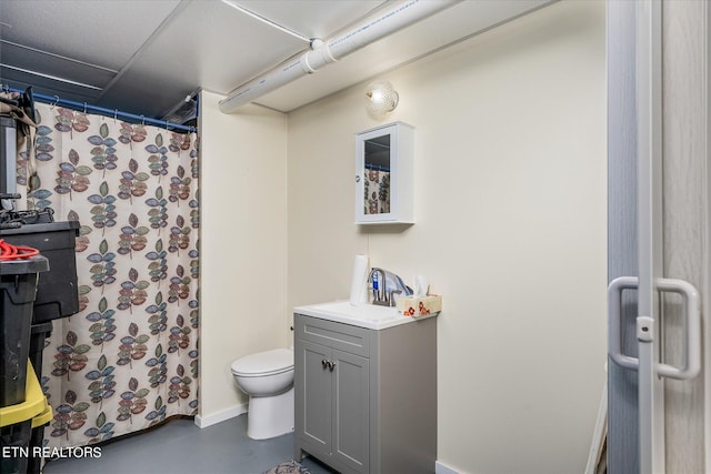 bathroom featuring finished concrete flooring, a shower with shower curtain, vanity, and toilet
