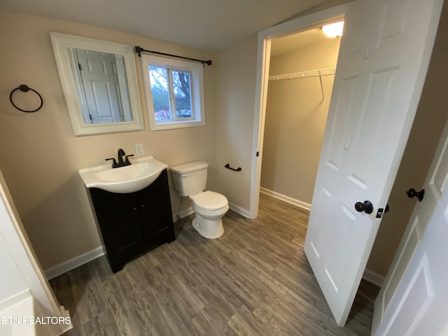 bathroom with toilet, hardwood / wood-style floors, and vanity