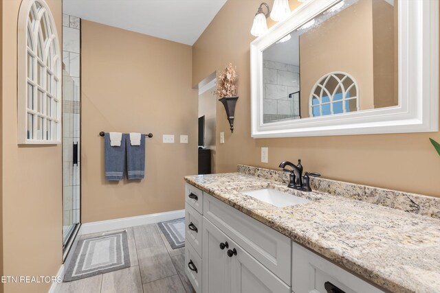 bathroom featuring vanity and a shower with shower door