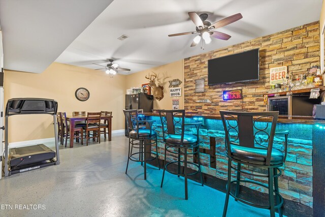 bar with wine cooler, ceiling fan, and black refrigerator