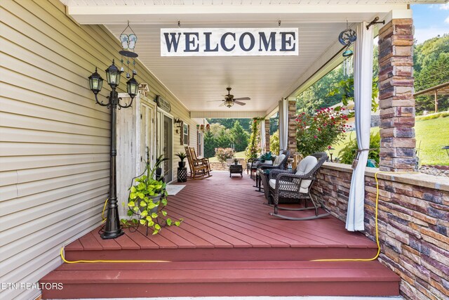 wooden deck with a porch and ceiling fan