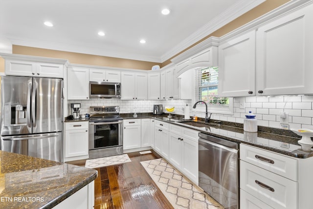 kitchen with stainless steel appliances, white cabinetry, dark hardwood / wood-style flooring, and ornamental molding