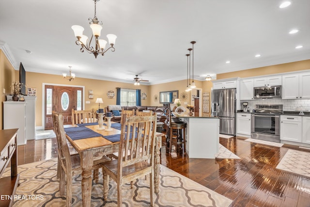 dining space featuring ceiling fan with notable chandelier, dark hardwood / wood-style floors, and crown molding