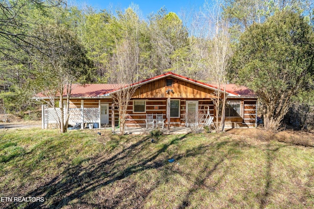 view of front of house with metal roof and a front lawn