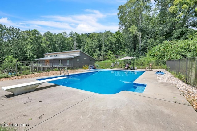 view of pool featuring a patio and a diving board