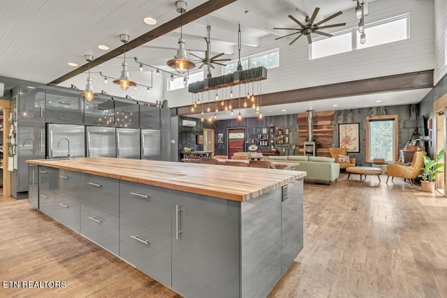 kitchen featuring ceiling fan, gray cabinets, butcher block countertops, and light hardwood / wood-style floors