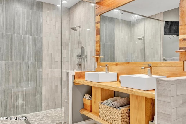 bathroom with a shower with door and dual bowl vanity