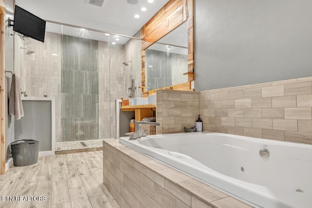 bathroom featuring shower with separate bathtub and wood-type flooring