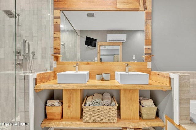 bathroom featuring dual bowl vanity, a wall mounted AC, and a shower with shower door