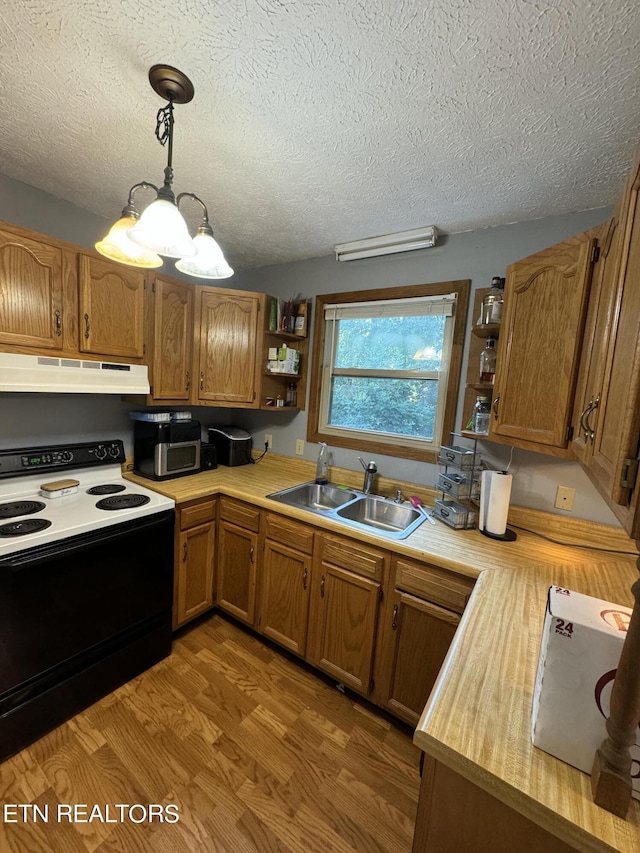 kitchen with sink, hardwood / wood-style flooring, hanging light fixtures, range with electric cooktop, and a textured ceiling