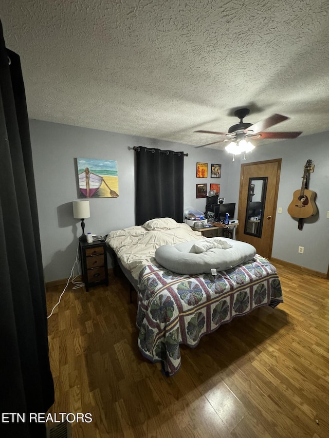 bedroom featuring hardwood / wood-style flooring, ceiling fan, and a textured ceiling