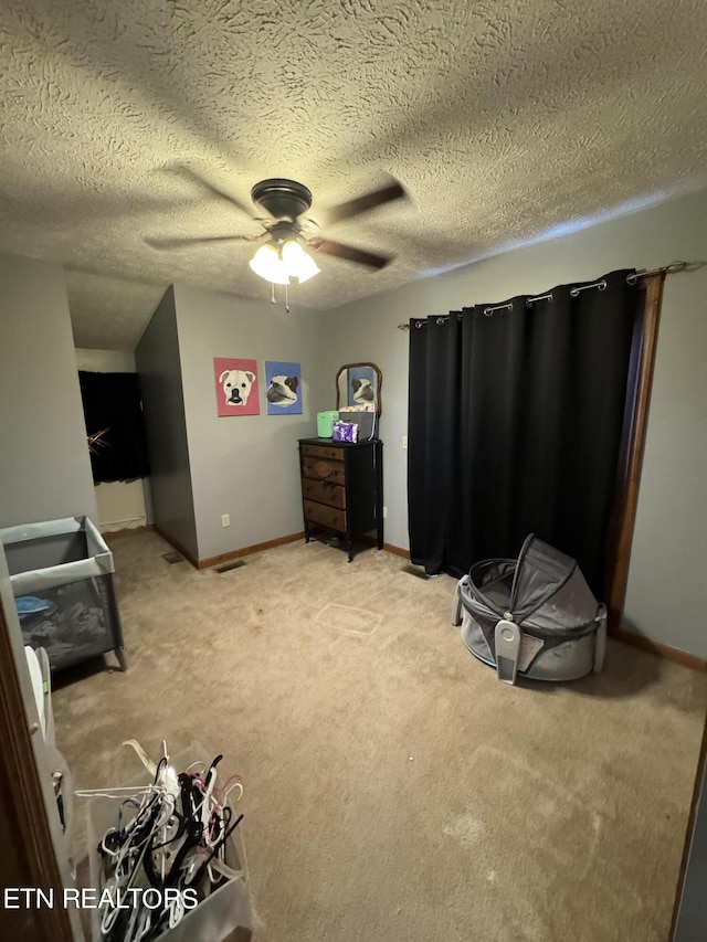 interior space featuring light carpet, ceiling fan, and a textured ceiling