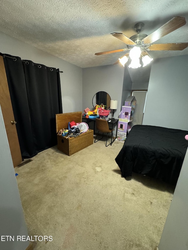 bedroom with ceiling fan, carpet, and a textured ceiling