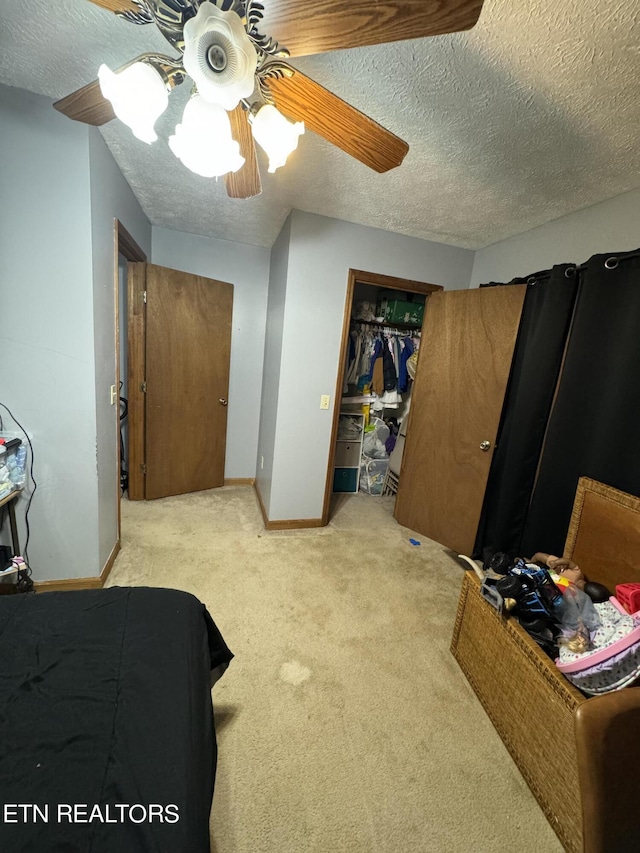 carpeted bedroom featuring ceiling fan, a textured ceiling, and a closet