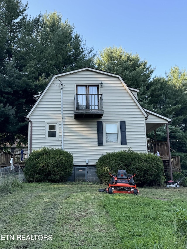 view of property exterior with a yard and a balcony