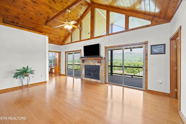 unfurnished living room featuring wooden ceiling, a fireplace, beamed ceiling, and light hardwood / wood-style floors