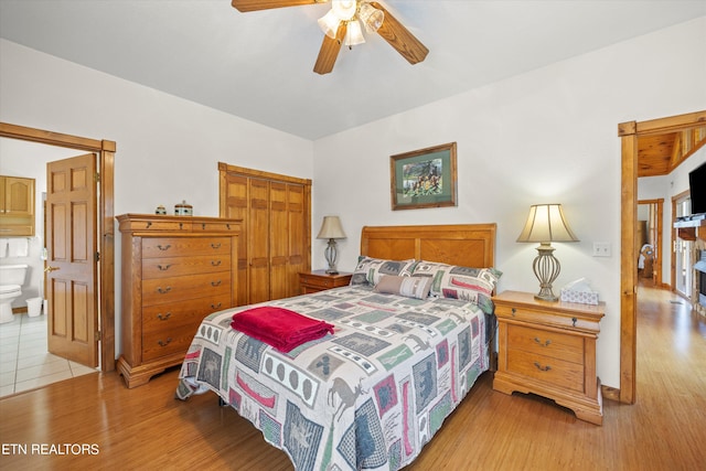 bedroom featuring ceiling fan, light wood-type flooring, ensuite bathroom, and a closet