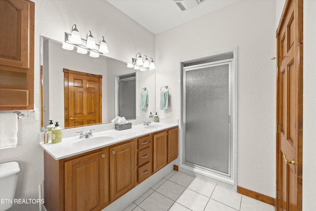 bathroom featuring a shower with shower door, tile patterned floors, dual vanity, and toilet