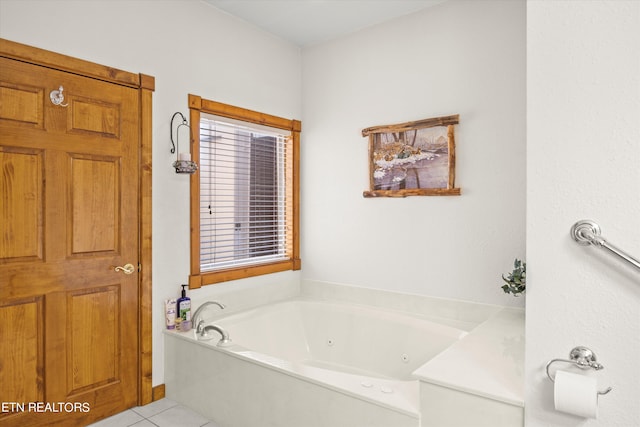 bathroom with a washtub and tile patterned flooring