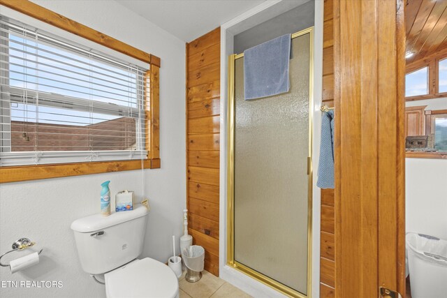 bathroom featuring a shower with shower door, toilet, and tile patterned flooring