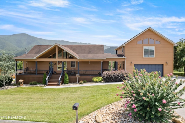 view of front of property featuring a garage, a front yard, and a mountain view