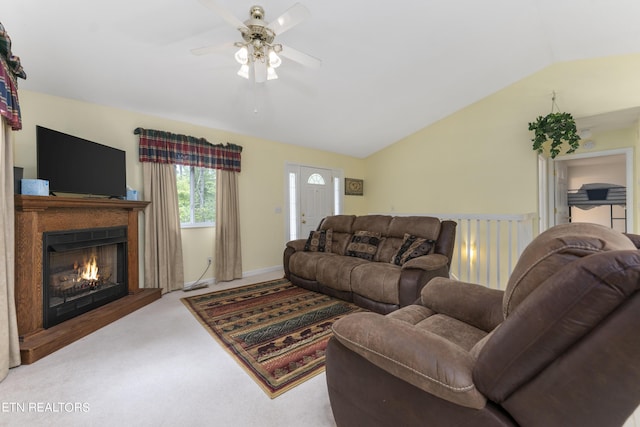 carpeted living room with ceiling fan and vaulted ceiling