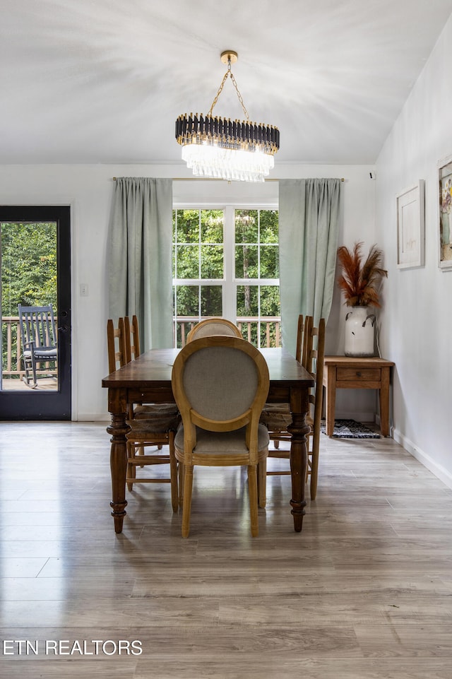 dining space featuring hardwood / wood-style floors and a chandelier