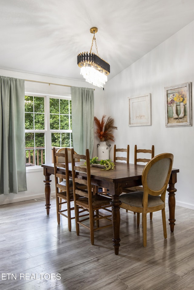 dining room with an inviting chandelier and wood-type flooring