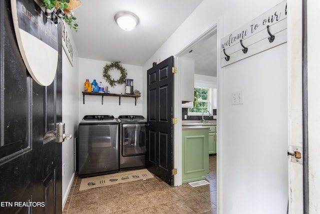 laundry area featuring sink, washer and clothes dryer, and light tile patterned floors