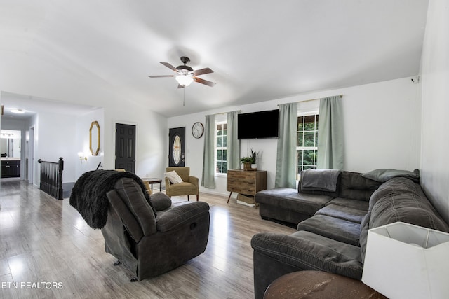 living room featuring light hardwood / wood-style floors, vaulted ceiling, and ceiling fan