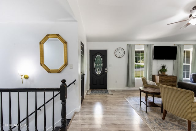 foyer entrance with ceiling fan and light hardwood / wood-style floors