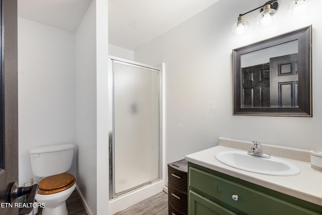 bathroom with an enclosed shower, vanity, hardwood / wood-style floors, and toilet