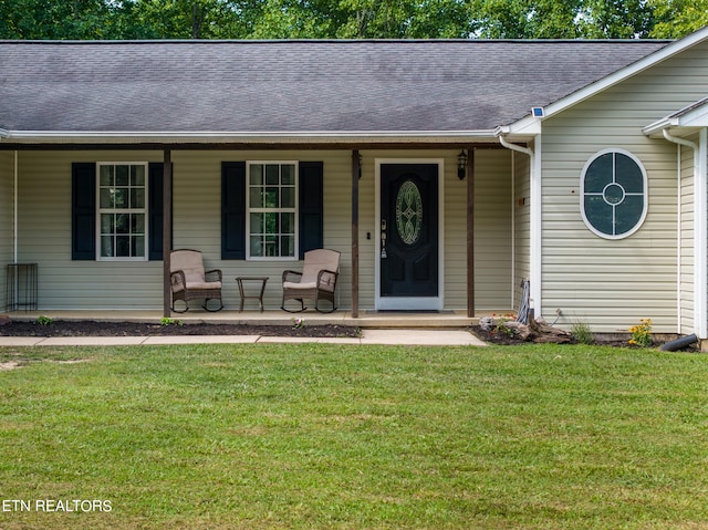 property entrance with a yard and covered porch