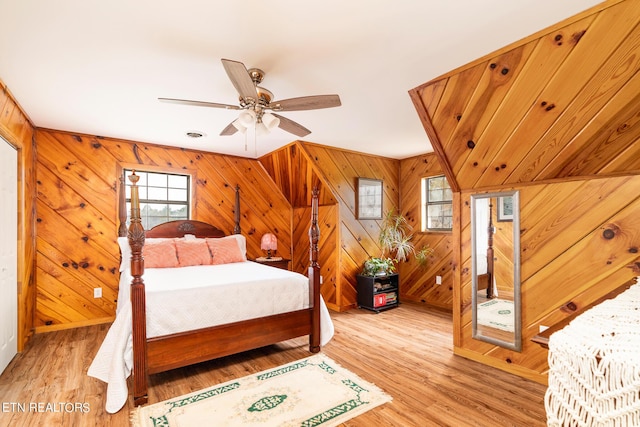 bedroom with wooden walls and light wood finished floors