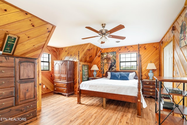 bedroom with multiple windows, wooden walls, light hardwood / wood-style flooring, and ceiling fan