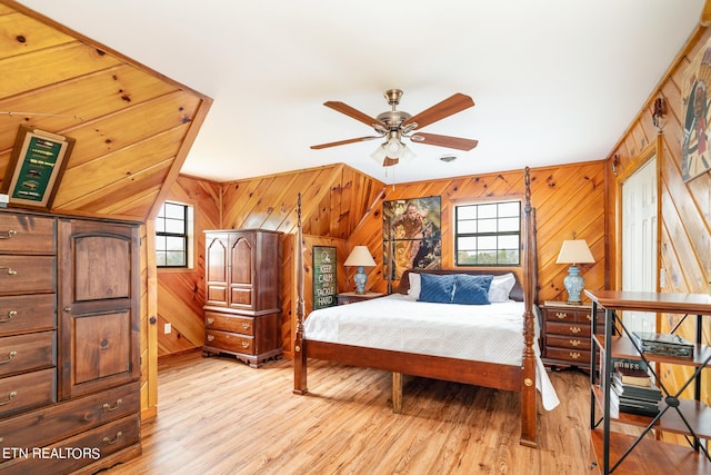 bedroom with light wood-style flooring and wooden walls