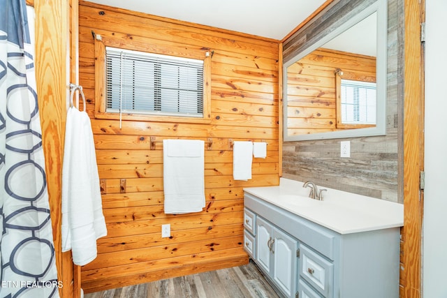 bathroom featuring wood finished floors, wooden walls, and vanity