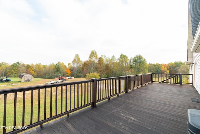 wooden deck with an outdoor structure, a yard, and a shed