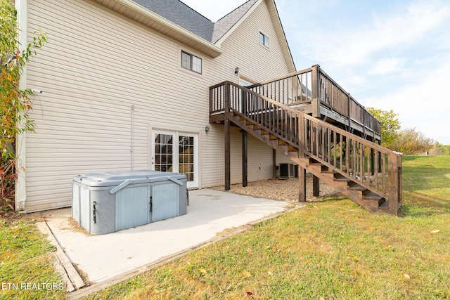 back of property with central air condition unit, a wooden deck, stairs, a yard, and a patio