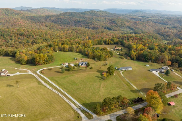 bird's eye view featuring a mountain view, a rural view, and a wooded view