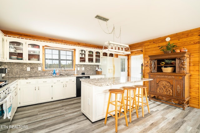 kitchen with tasteful backsplash, light wood-style floors, white appliances, and a kitchen island