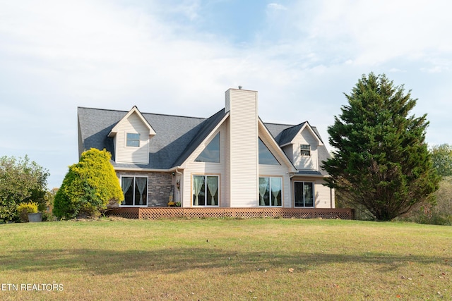rear view of house with a chimney and a yard