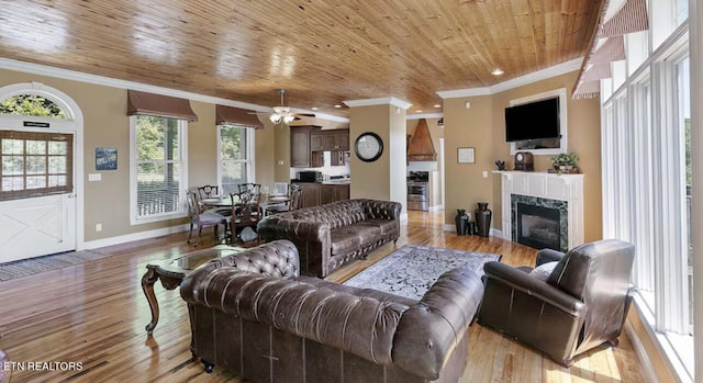 living room featuring wood ceiling, light hardwood / wood-style flooring, ornamental molding, and a high end fireplace