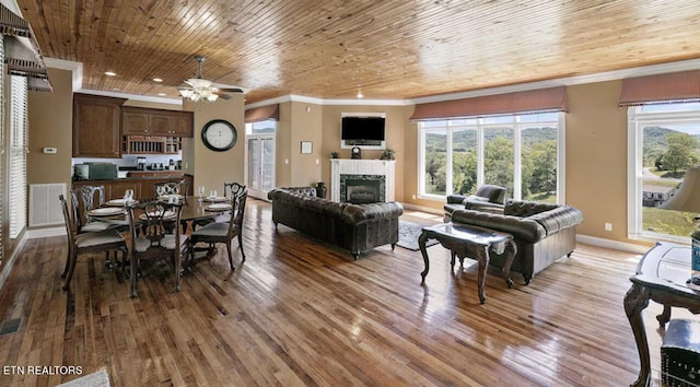 dining area with ceiling fan, hardwood / wood-style floors, and a tile fireplace