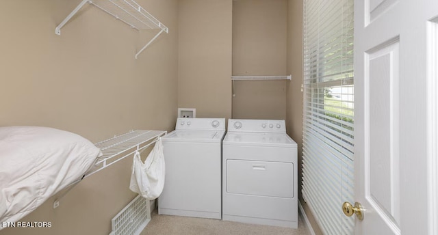 laundry area featuring light colored carpet and washer and clothes dryer