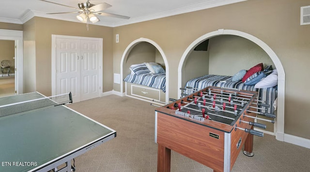 rec room with carpet flooring, crown molding, and ceiling fan