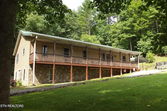 back of house with a lawn and covered porch